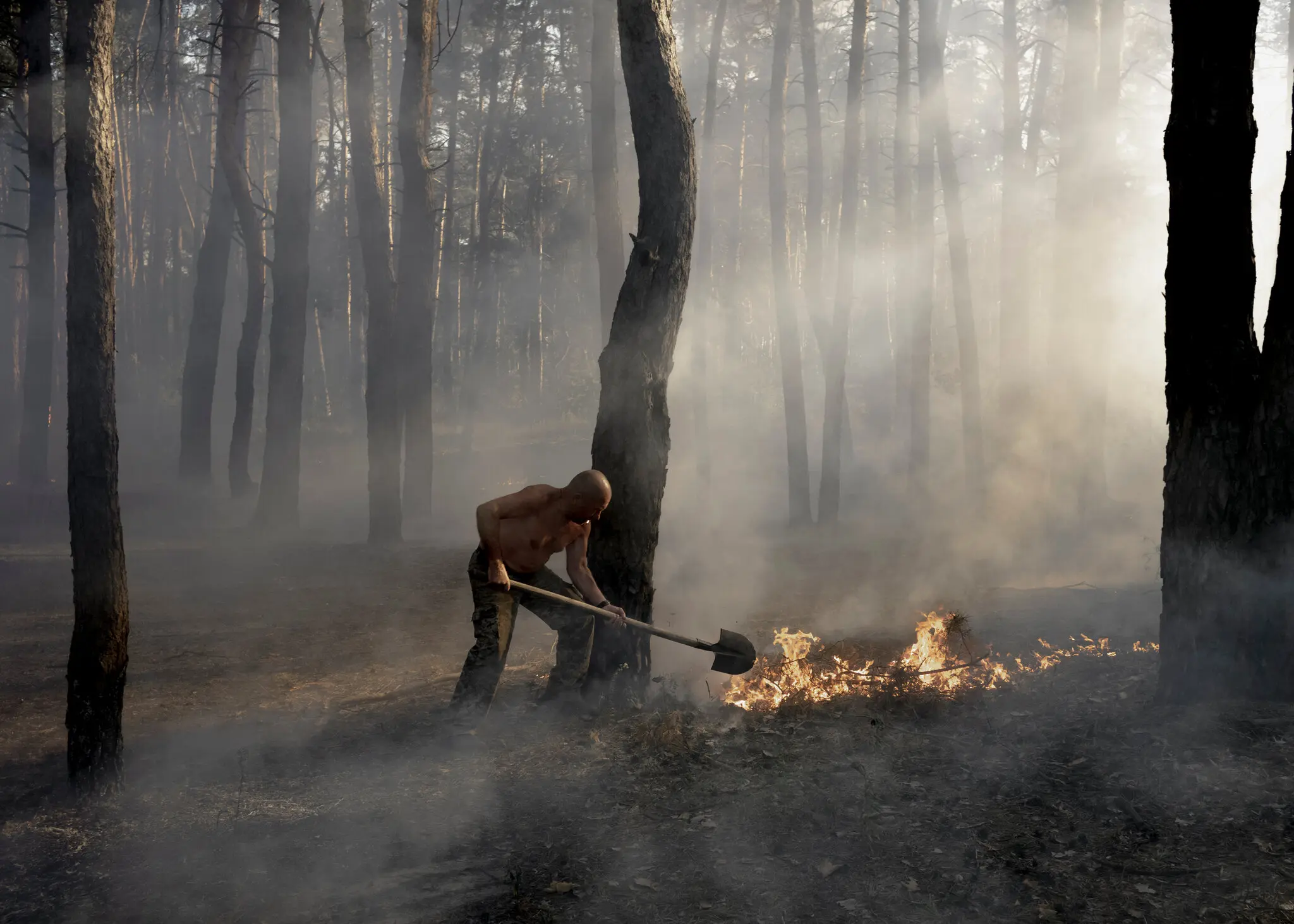 Український військовий гасить пожежу, що виникла після обстрілу в Куп'янську. Мешканці, які залишилися після російської окупації, кажуть, що звикли до обстрілів, але більшість готові миттєво втекти.